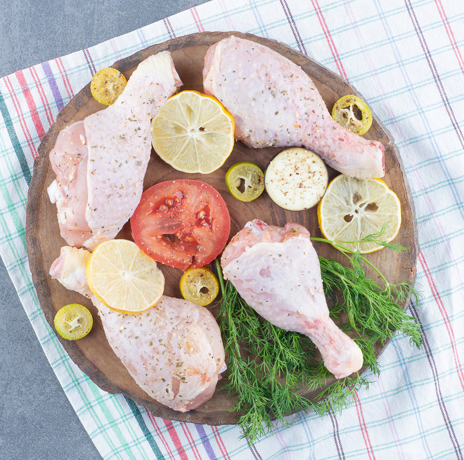 Raw chicken drumsticks on wood piece فخذ دجاج - الصورة 1